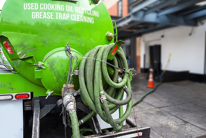 a grease trap being pumped by a sanitation technician in Boynton Beach FL